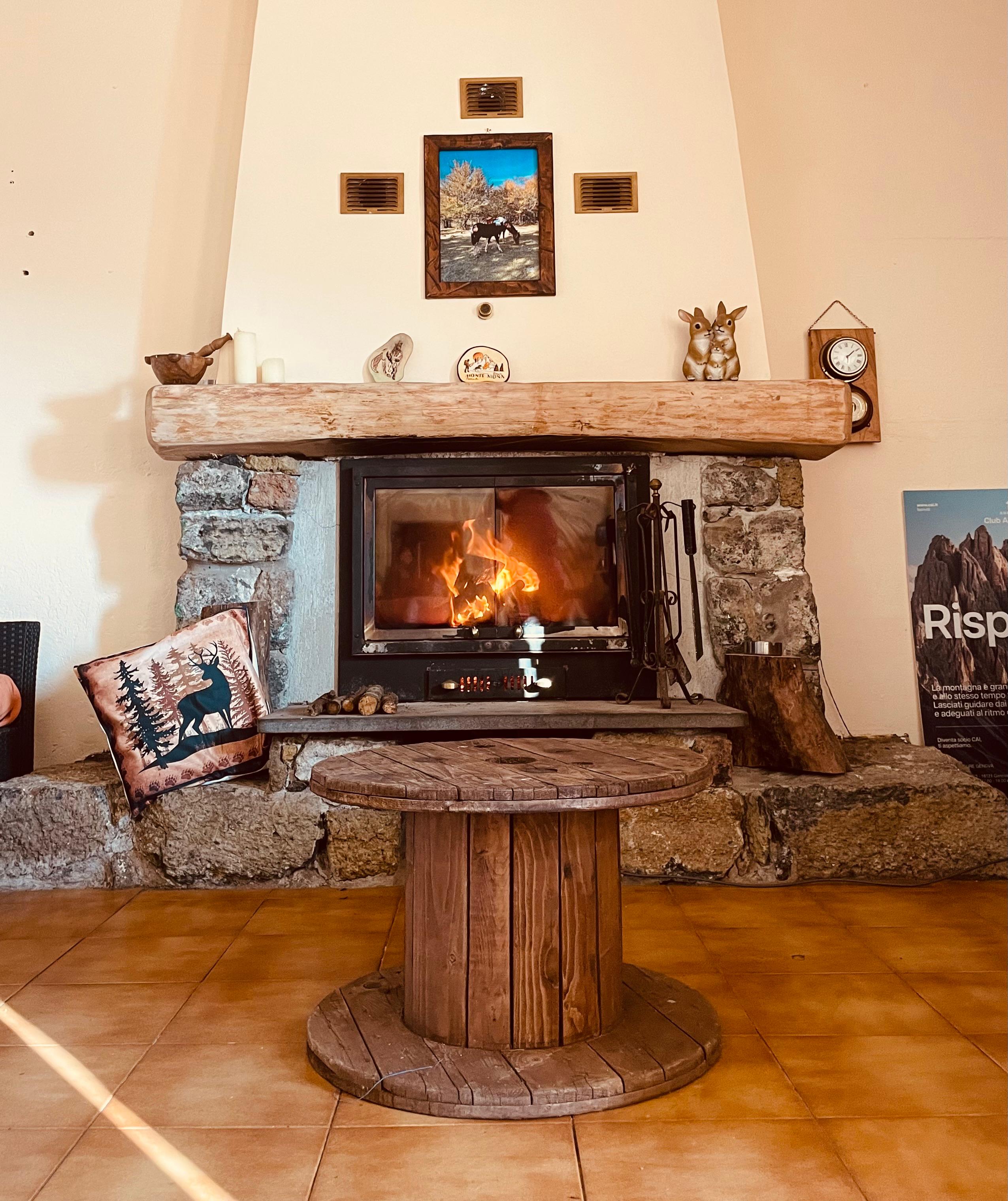Woodburning stove mounted in a fireplace with a warm blaze in the centre